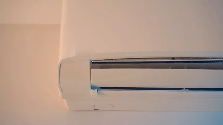ידיים פותחות את רשת הפתח של מזגן מיני מרכזי בתקרה